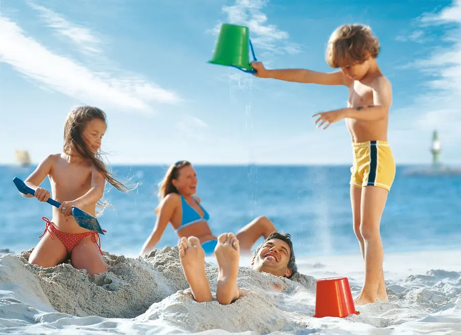 Kinder buddeln am Sandstrand im Ostseebad Warnemünde, Mecklenburgische Ostseeküste Kinder buddeln am Sandstrand im Ostseebad Warnemünde, Mecklenburgische Ostseeküste