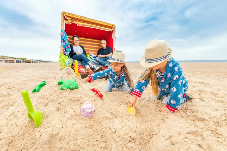 Kleine Urlauber bauen Sandburgen am Strand von Trassenheide.